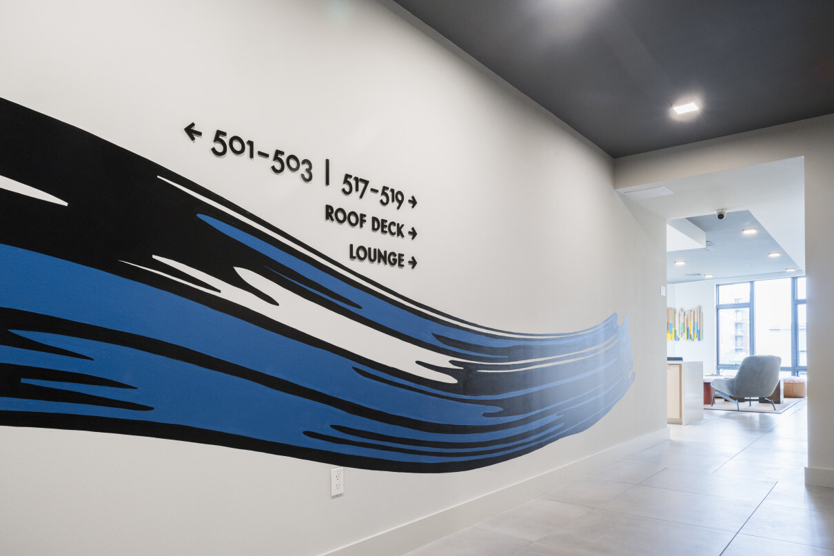 Arthaus wall directional signage with swoosh