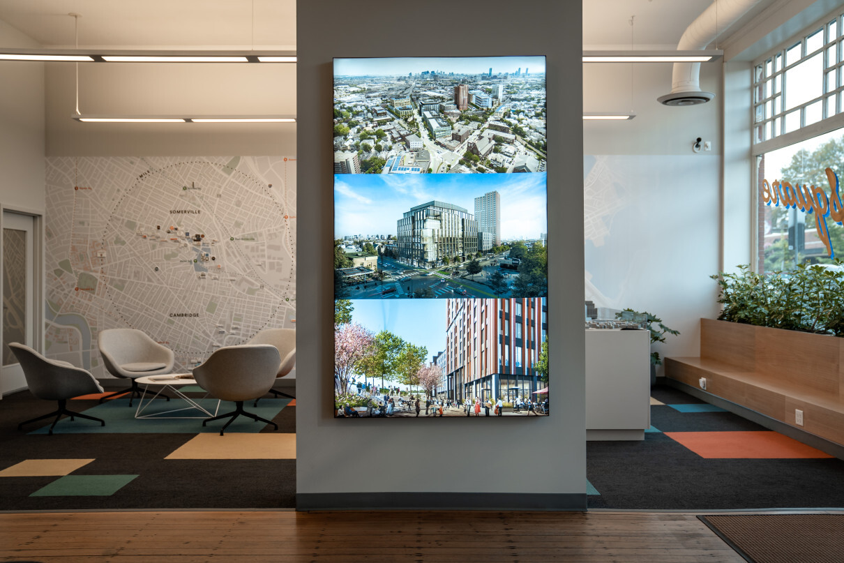 Stacked screens with renderings at USQ marketing office